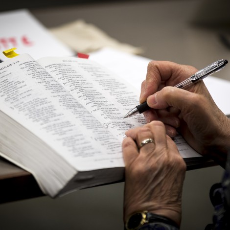 Hands writing in a textbook
